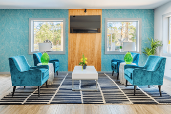A lobby with blue chairs and a white coffee table